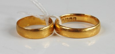 Lot 383 - A 22ct gold wedding band, size O/P; together...