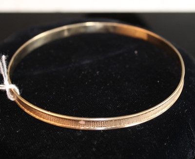 Lot 379 - A 9ct gold engine turned large bangle, 16.8g,...