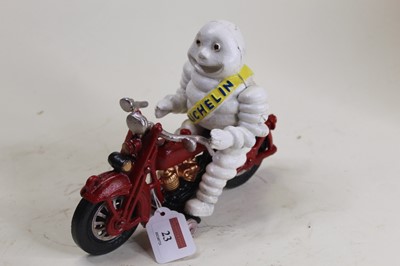 Lot 23 - A cast iron model of the Michelin Man riding a...