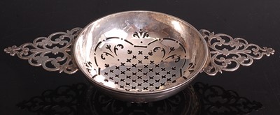 Lot 1044 - A George II silver twin-handled lemon strainer,...