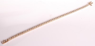 Lot 1121 - A yellow metal diamond tennis bracelet, having...