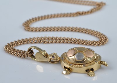 Lot 1124 - A yellow metal articulated tortoise pendant,...