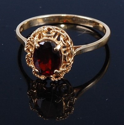 Lot 442 - A modern yellow metal garnet set dress ring,...