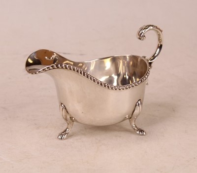 Lot 250 - A silver sauceboat, having a gadrooned rim...