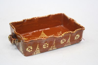 Lot 211 - A twin handle slipware dish, of shaped...
