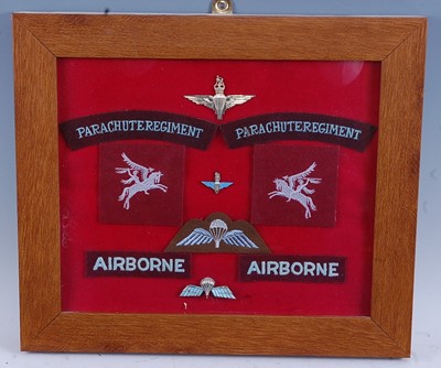 Lot 79 - A framed display of cloth shoulder titles,...