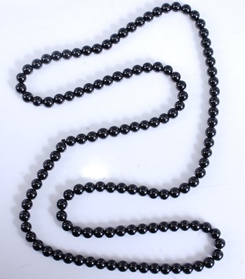 Lot 2520 - A long row of 126 black spherical beads,...
