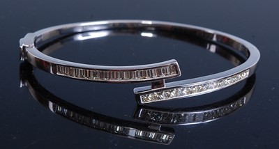 Lot 2211 - A white metal diamond hinged crossover bangle,...