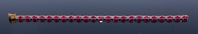 Lot 2210 - A yellow metal, ruby and white stone tennis...