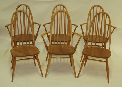 Lot 519 - A set of four Ercol blond elm stickback elbow...
