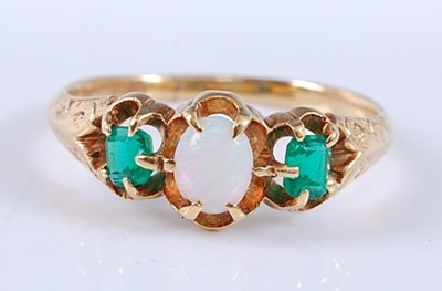 Lot 2534 - A yellow metal, opal and emerald three stone...