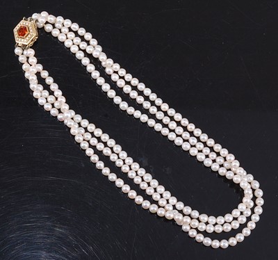 Lot 2527 - A three-row cultured pearl choker, having 77,...