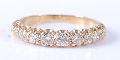 Lot 2569 - A yellow metal diamond half hoop eternity ring,...
