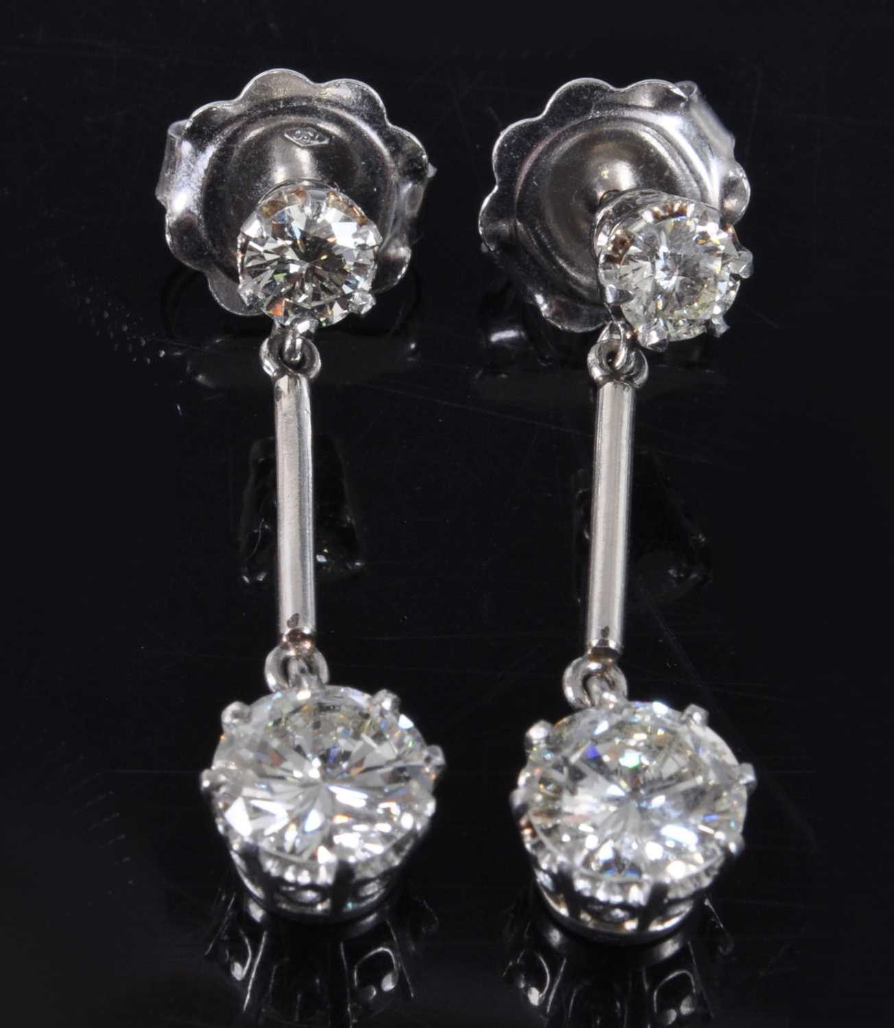 Lot 1161 - A pair of white metal diamond drop earrings,...