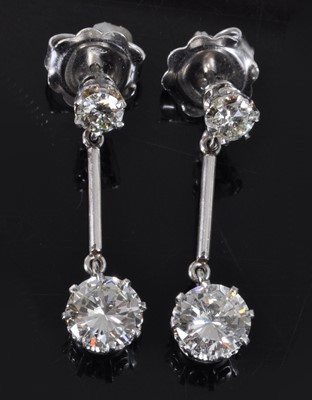 Lot 1161 - A pair of white metal diamond drop earrings,...