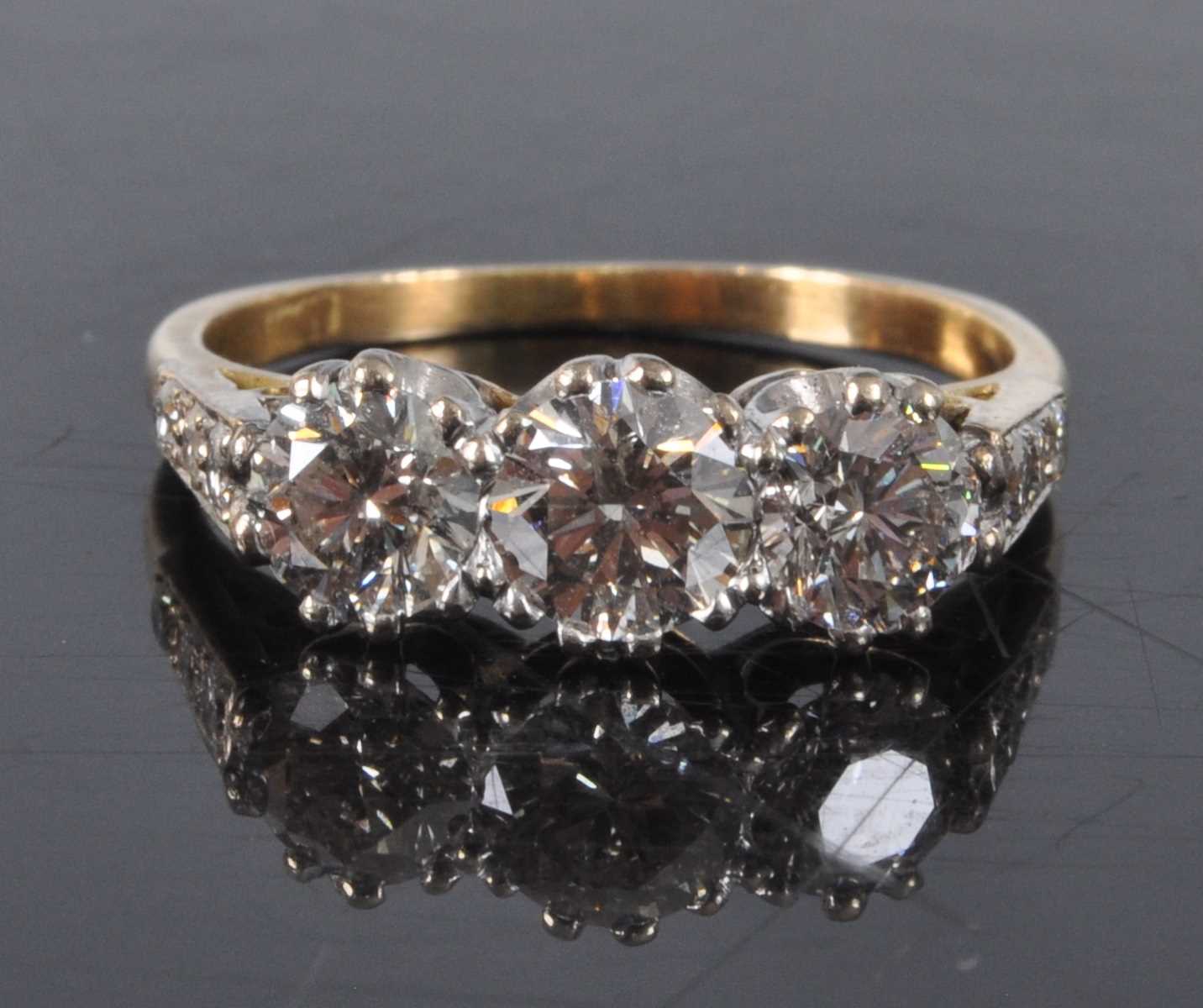 Lot 1162 - A yellow and white metal diamond three stone...