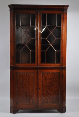 Lot 1440 - A late Georgian oak freestanding corner...