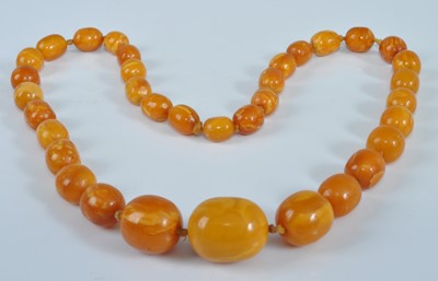 Lot 1184 - An amber single string necklace, the graduated...