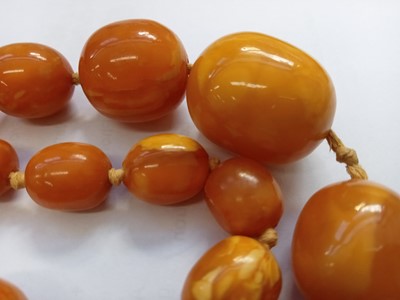 Lot 1184 - An amber single string necklace, the graduated...