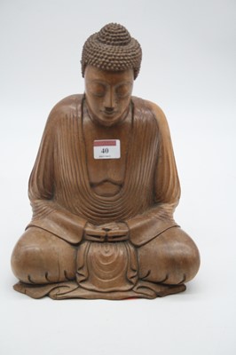 Lot 40 - A carved hardwood figure of a deity in typical...
