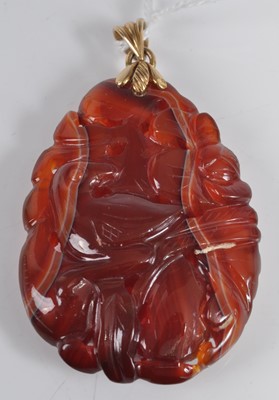 Lot 461 - A Chinese? carved agate pendant, featuring a...