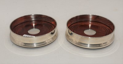 Lot 244 - A pair of Elizabeth II silver wine coasters,...