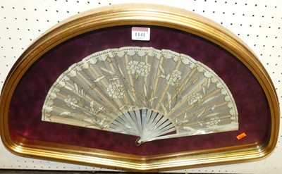 Lot 1141 - A cased mother of pearl and silk decorated fan,...
