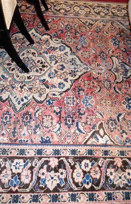 Lot 1156 - An Iranian red ground woollen rug, having...