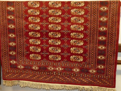 Lot 1160 - A Persian woollen red ground Bokhara rug, 180...