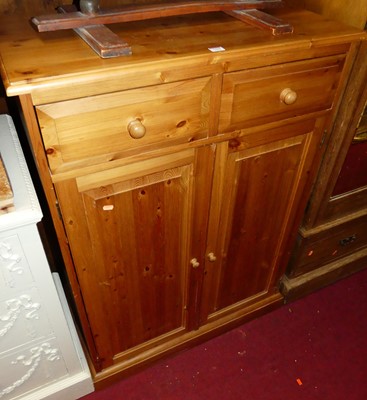 Lot 1194 - A modern pine double door side cupboard, with...