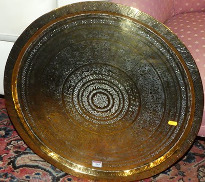 Lot 1265 - An Eastern engraved brass circular tray of...