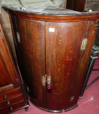 Lot 1357 - An early 19th century oak bowfront double door...