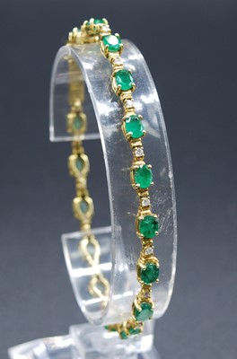 Lot 2619 - A yellow metal, emerald and diamond line...