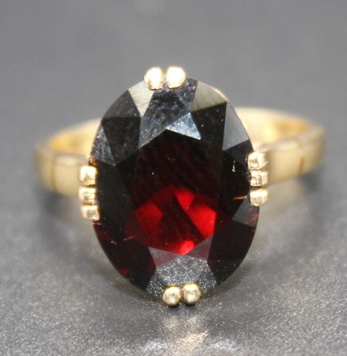 Lot 2778 - A modern yellow metal garnet set dress ring,...