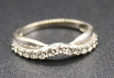 Lot 2839 - A modern white metal and diamond set half hoop...