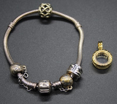 Lot 521 - A Pandora bracelet with charms, safety chain,...