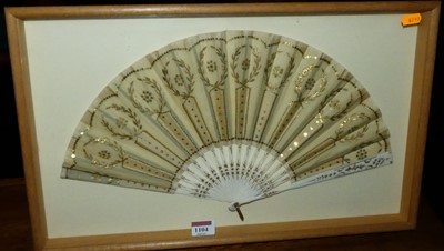 Lot 1104 - A painted silk and faux ivory fan in glazed...
