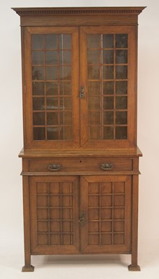 Lot 1146 - An Arts & Crafts oak bookcase cupboard, having...