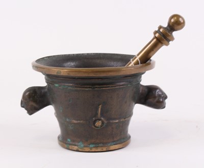 Lot 29 - A bronze pestle and mortar, the mortar flanked...