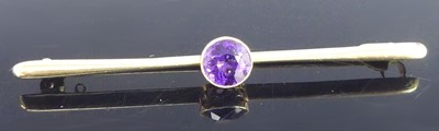 Lot 456 - A yellow metal amethyst bar brooch, having a...
