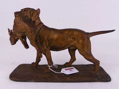 Lot 41 - A painted spelter figure of a hound clutching...