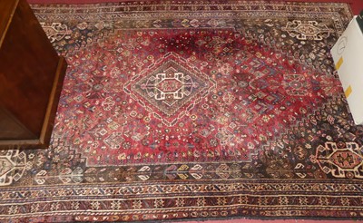 Lot 1140 - An Iranian red ground woollen Shiraz rug,...