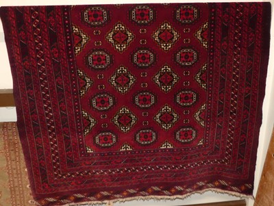 Lot 1145 - A Persian woollen red ground Bokhara rug,...