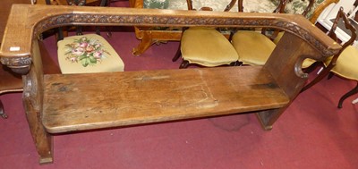 Lot 1299 - An Arts & Crafts oak long church pew, having...
