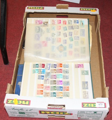 Lot 673 - A green canvas bound stamp album containing ...