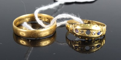 Lot 451 - An 18ct gold wedding band, size R; together...