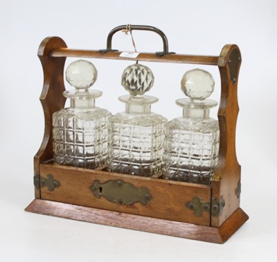 Lot 99 - An Edwardian brass mounted oak three bottle...