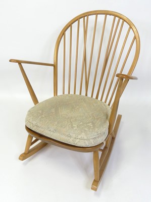 Lot 304 - An Ercol blond elm stickback rocking elbow...