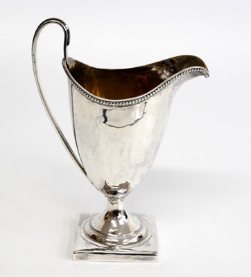 Lot 1145 - A George III silver helmet shaped cream jug,...