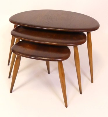 Lot 321 - An Ercol dark elm nest of three 'Pebble'...